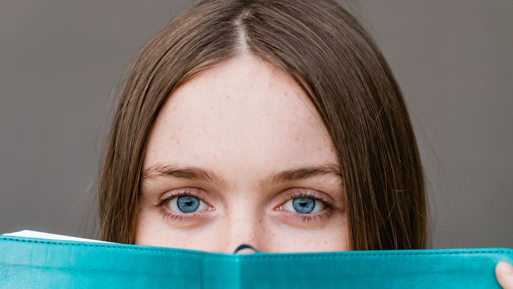 Enhancing Reading Speed: Woman Engrossed in Teal Book