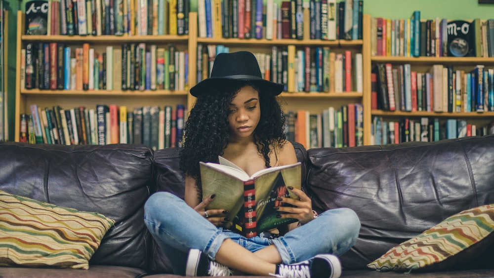 Peripheral Reading: Woman Reading on Black Leather Couch