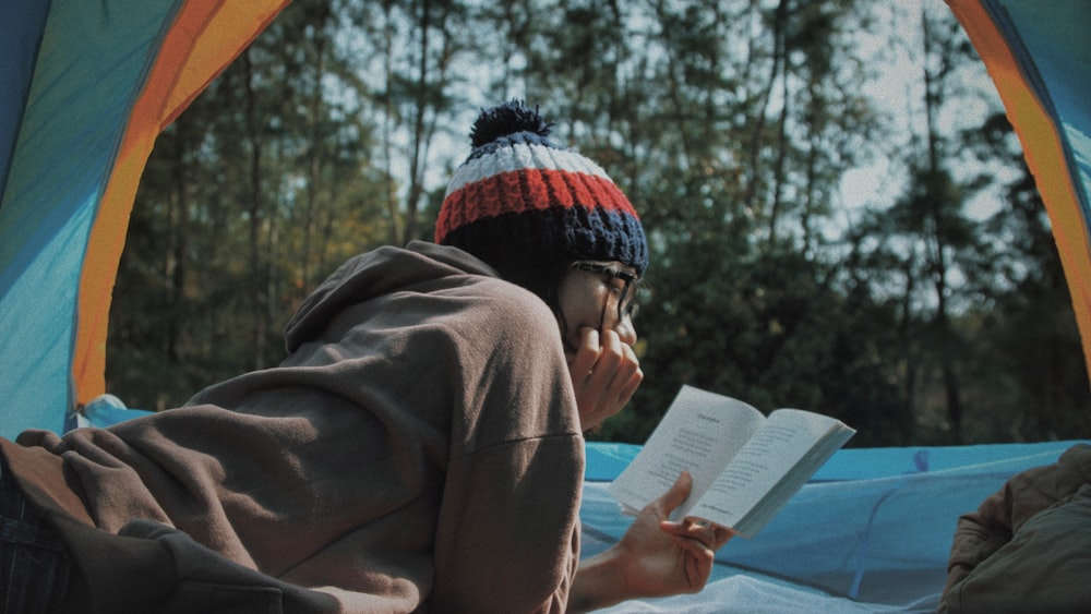 Speed Reading Outdoors: Woman Reading Book in Tent